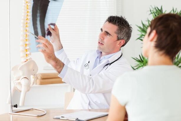 lekár ukazuje poškodenie chrbtice v dôsledku cervikálnej osteochondrózy